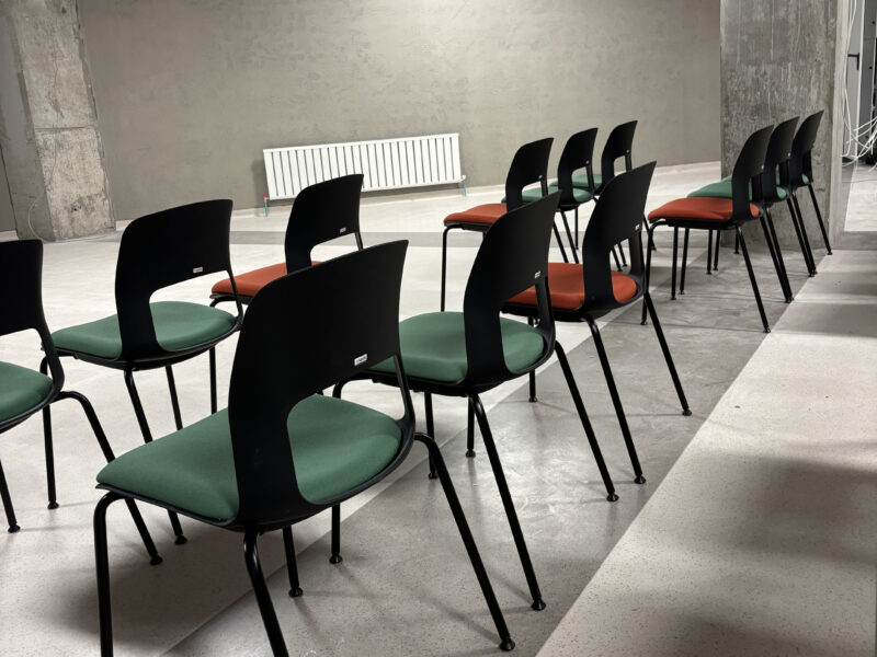Seminer alanı, sıralı yeşil ve siyah sandalyeler