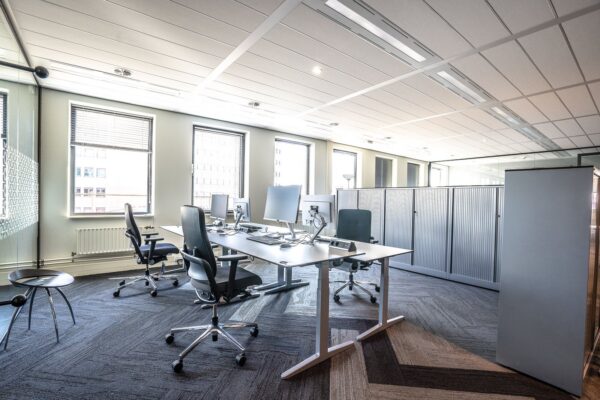 Bright and spacious modern office interior featuring sleek workstations and ergonomic chairs.