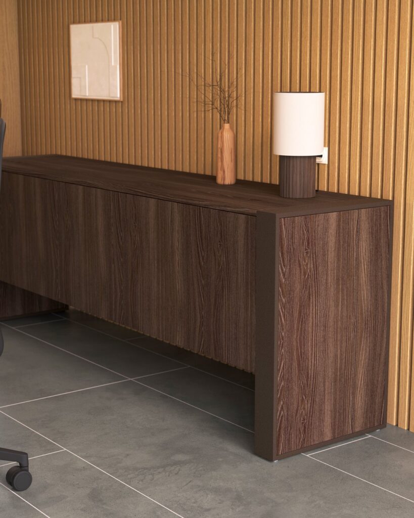 Plato — Dark wood textured console with a vase and lamp on top, in an office setting against a wood-paneled wall